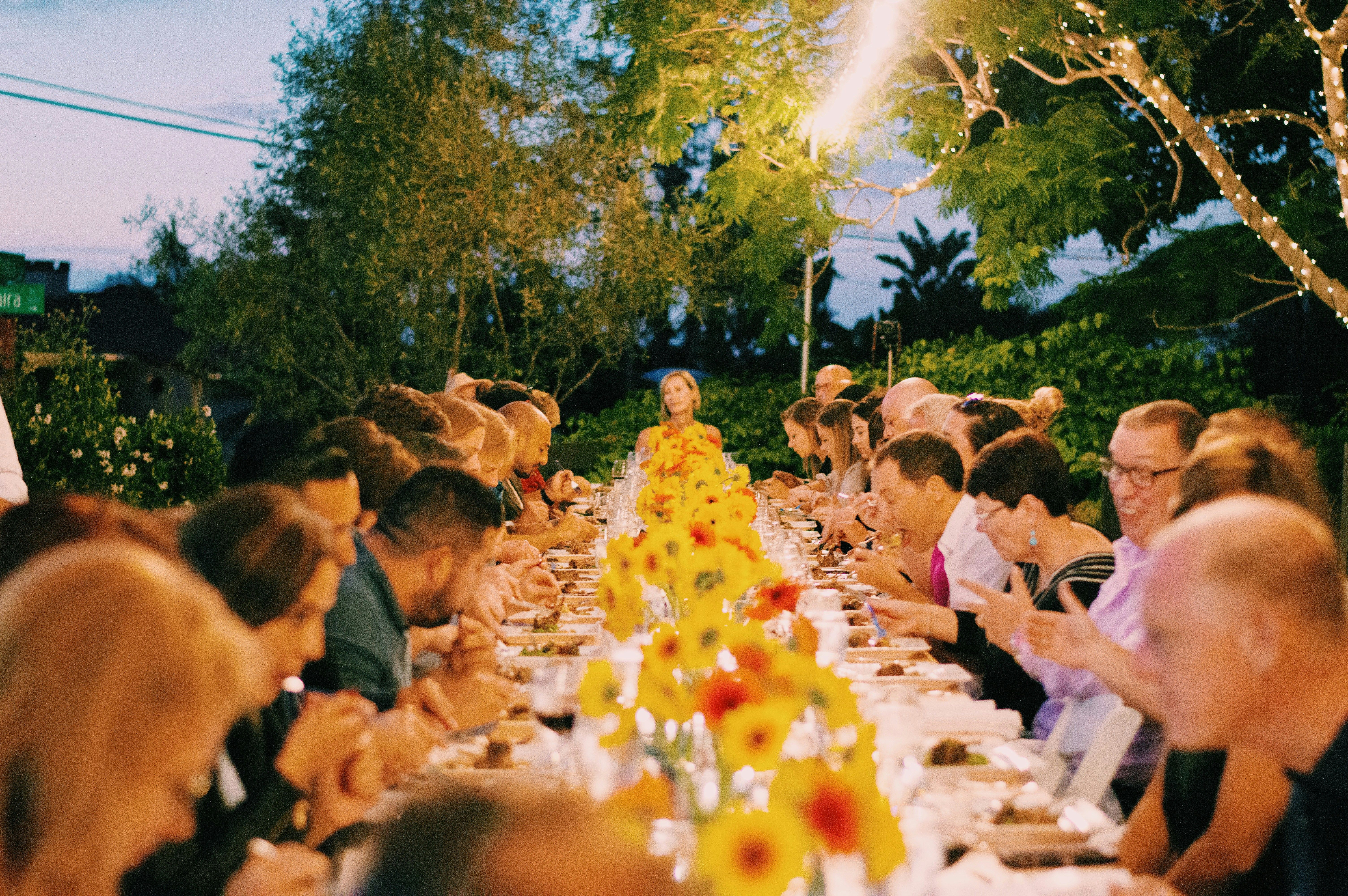 Sophisticated charity gala setup with round tables, ambient lighting, and a performance area for Broadway karaoke entertainment